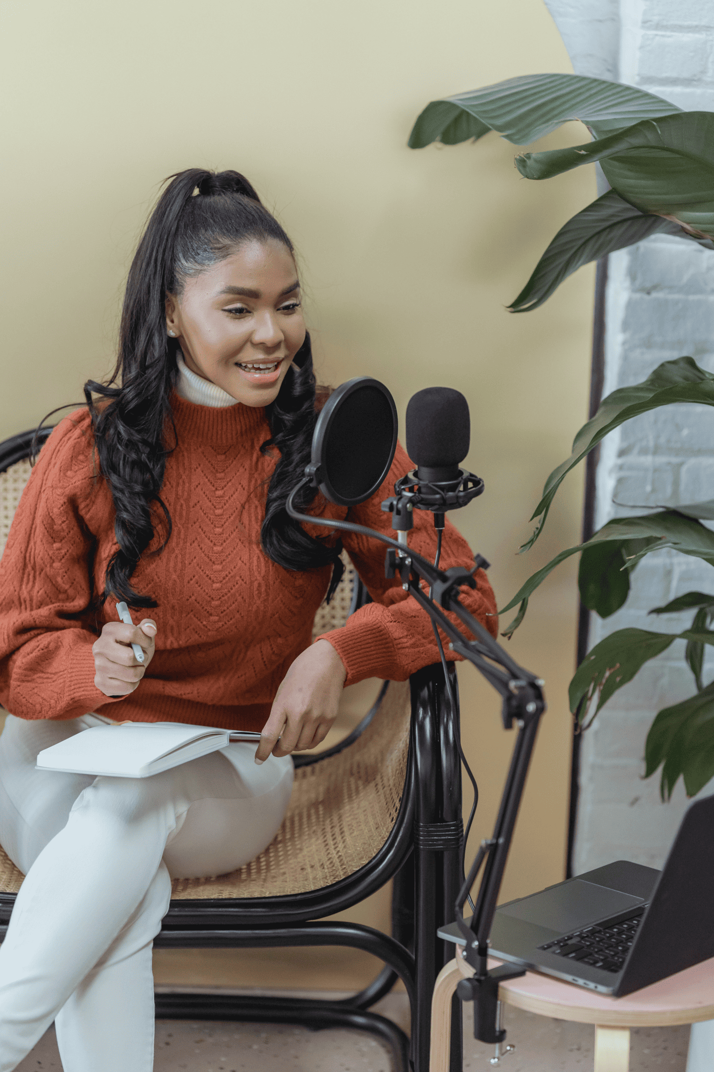 smiling-ethnic-woman-with-microphone-and-laptop-creating-podcast-in-studio